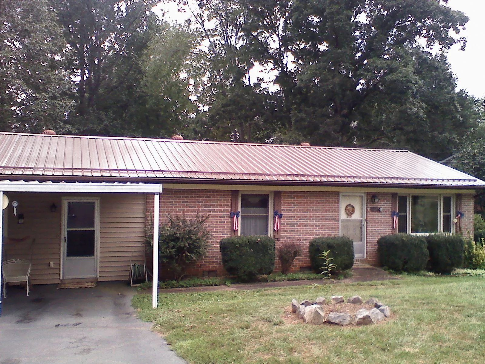 Bronze metal roof and carport on a brick ranch home — Roof Repair work by our crew in Rantoul